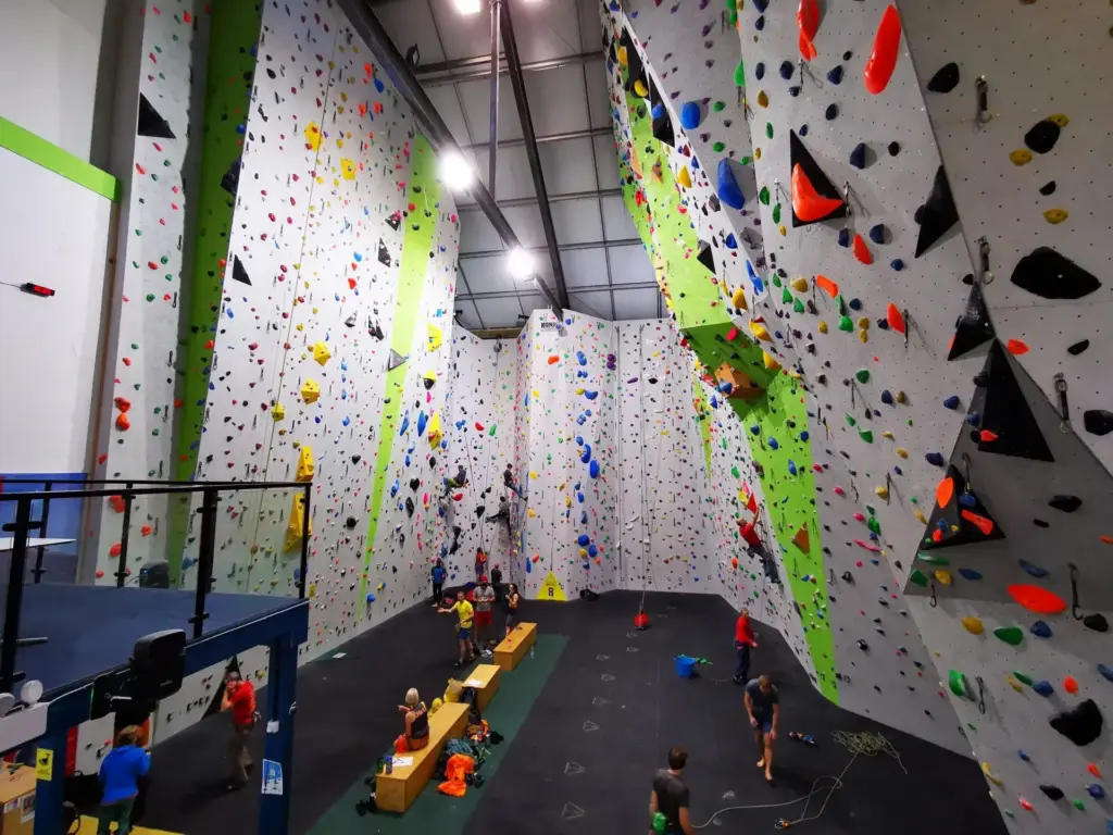 Inside of Beacon Climbing Centre With Colourful Climbing Walls & Lots of People Climbing & Getting Ready to Climb