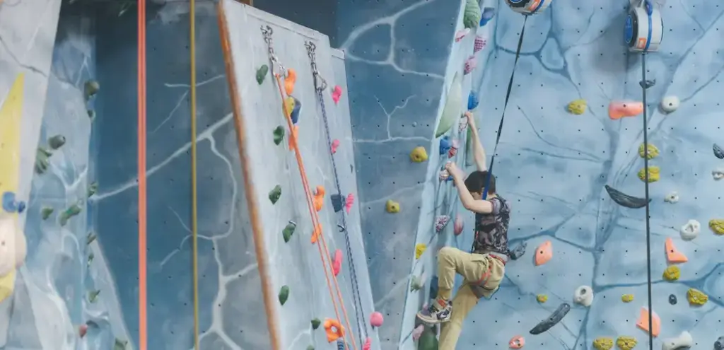 A Person Climbing Up A Large Section of a Rock Climbing Wall at Blue Spider Indoor Climbing Centre