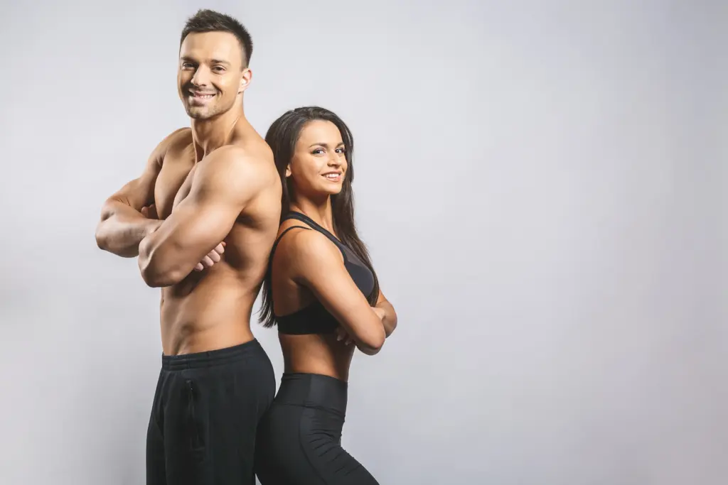 Male and Female Fitness Models Standing Back to Back With Their Arms Crossed