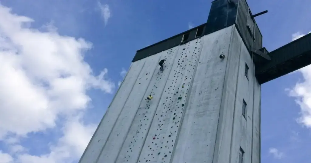 Large Section of the Exterior of ROKT Bouldering Gym in Huddersfield Showing Someone Ascending the Large Rock Wall